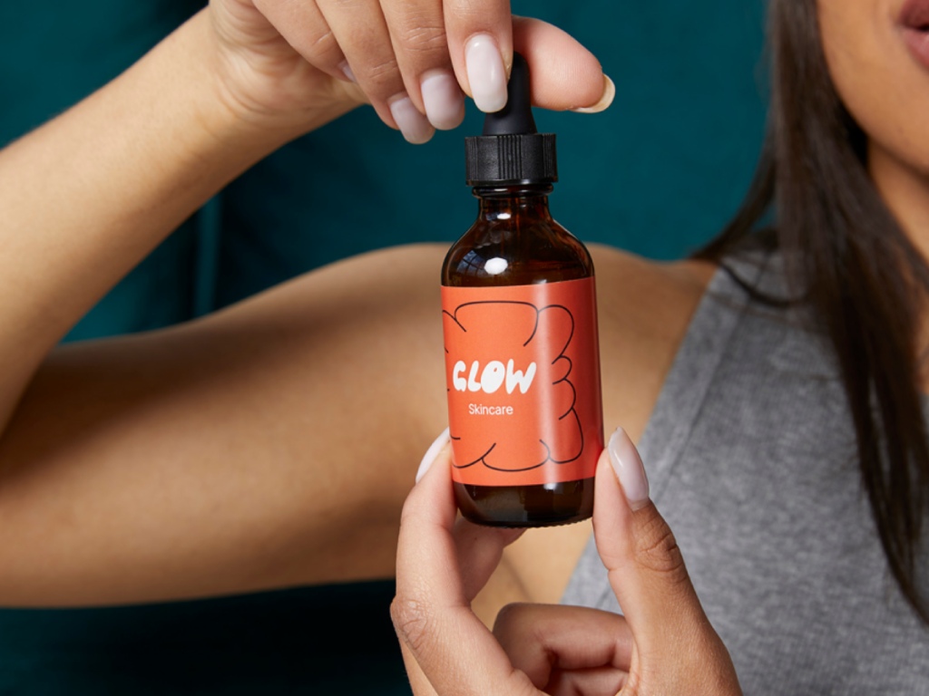 Beauty products What to sell on Shopify A woman holding a skincare product as an example of what to sell on Shopify.