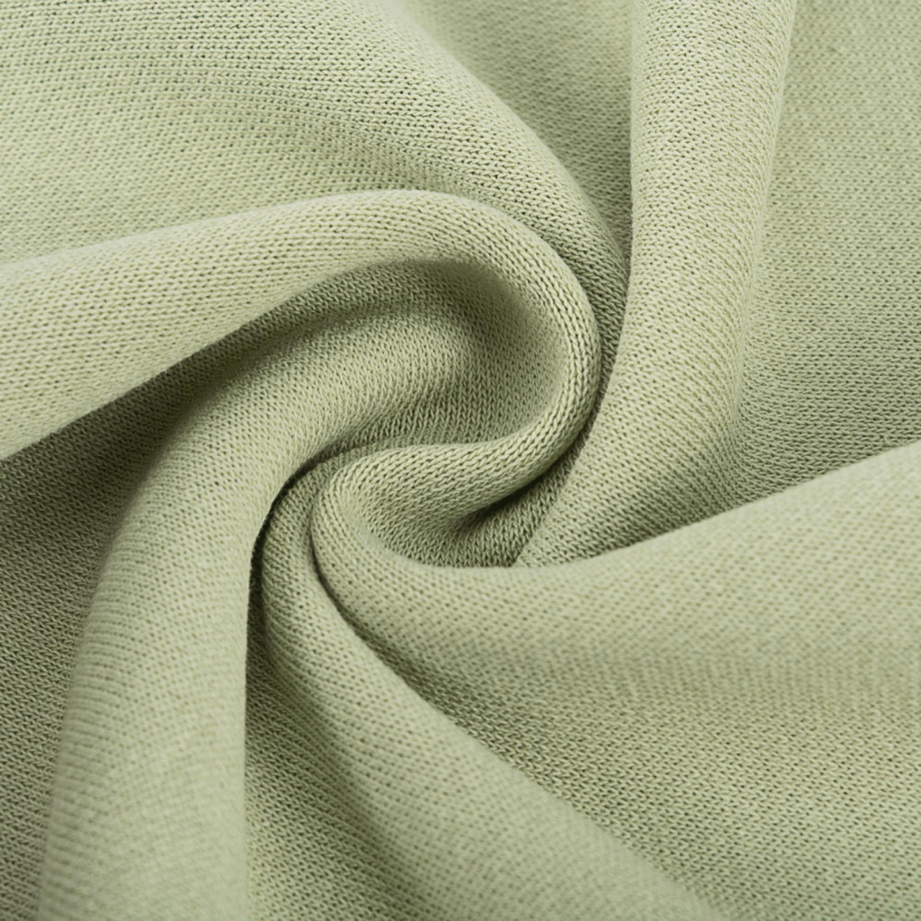 Cotton Types of fabric Close-up of light green cotton with a visible weave pattern, twisted into a spiral shape.