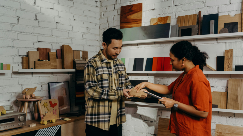 Create and sell your own products How to make money as an influencer A man and a woman passing a handmade product from wood.