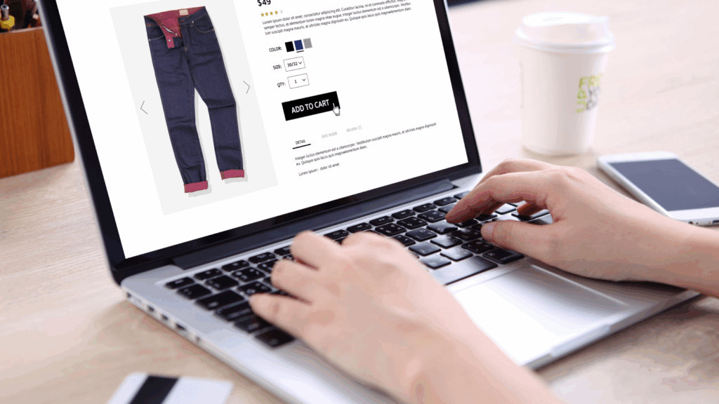 Decide where to sell How to start a dropshipping business A person using a laptop to buy jeans online.
