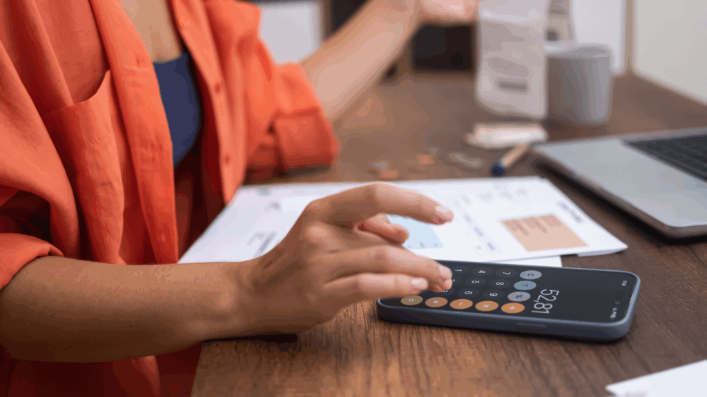 How profitable is dropshipping A woman using a mobile phone to perform calculations.