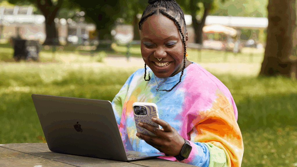 Market your products A woman smiles while working on her laptop.