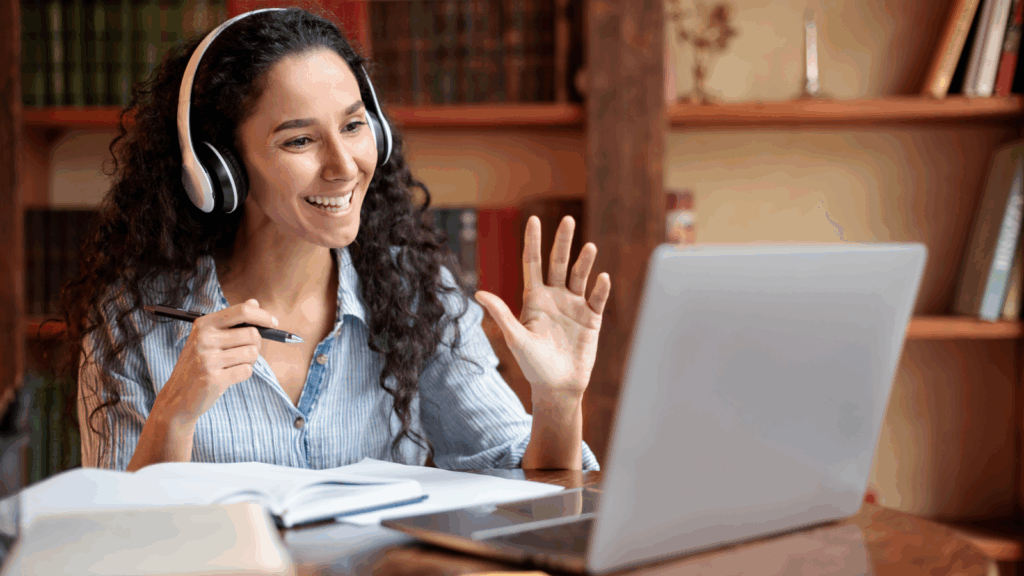 Online education and coaching Top 10 most successful businesses to start A woman in headphones sitting in front of a laptop and teaching online.