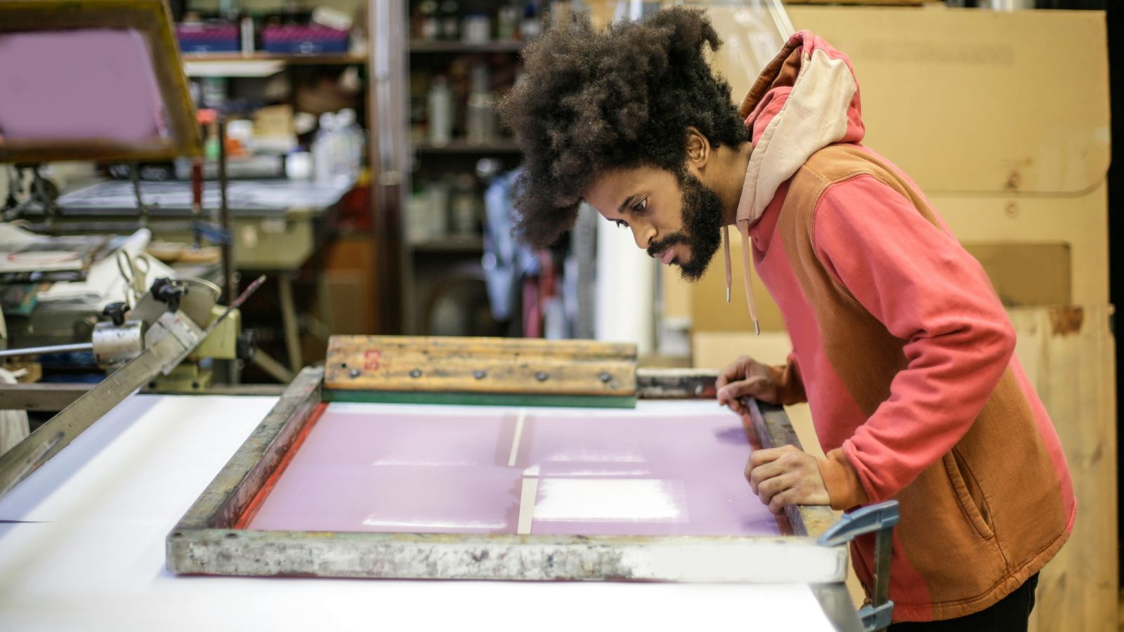 Screen printing Types of shirt printing A man checking if everything is correct before screen printing on a t-shirt.