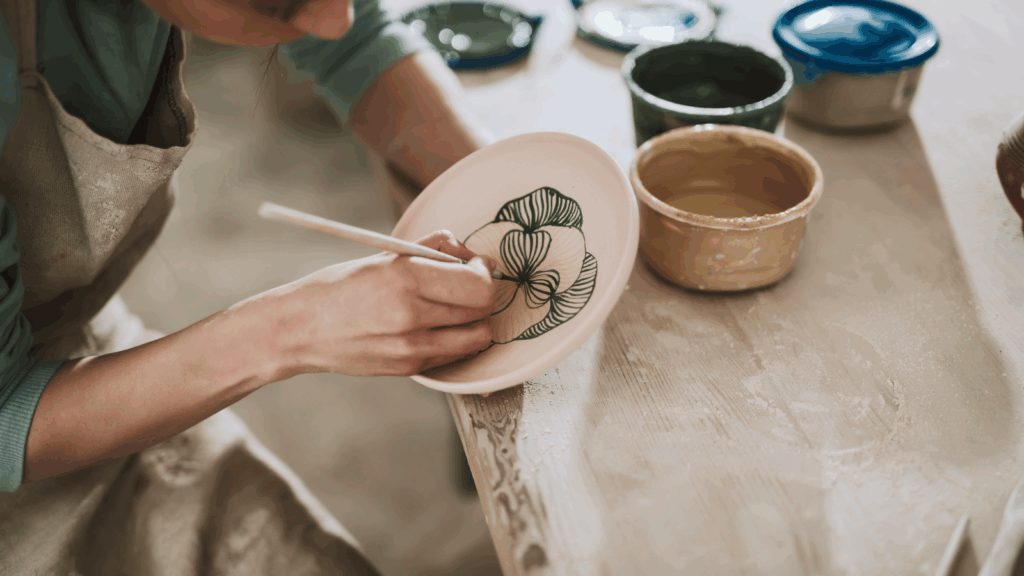 Sell handmade goods A woman painting a handmade plate.