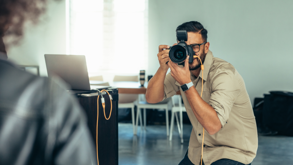 Selling stock photography and videography Side hustles that pay well A man capturing an image with a camera, focused on his subject in an outdoor setting.