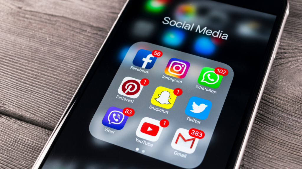 Social media management Most profitable businesses A phone with social media apps on.