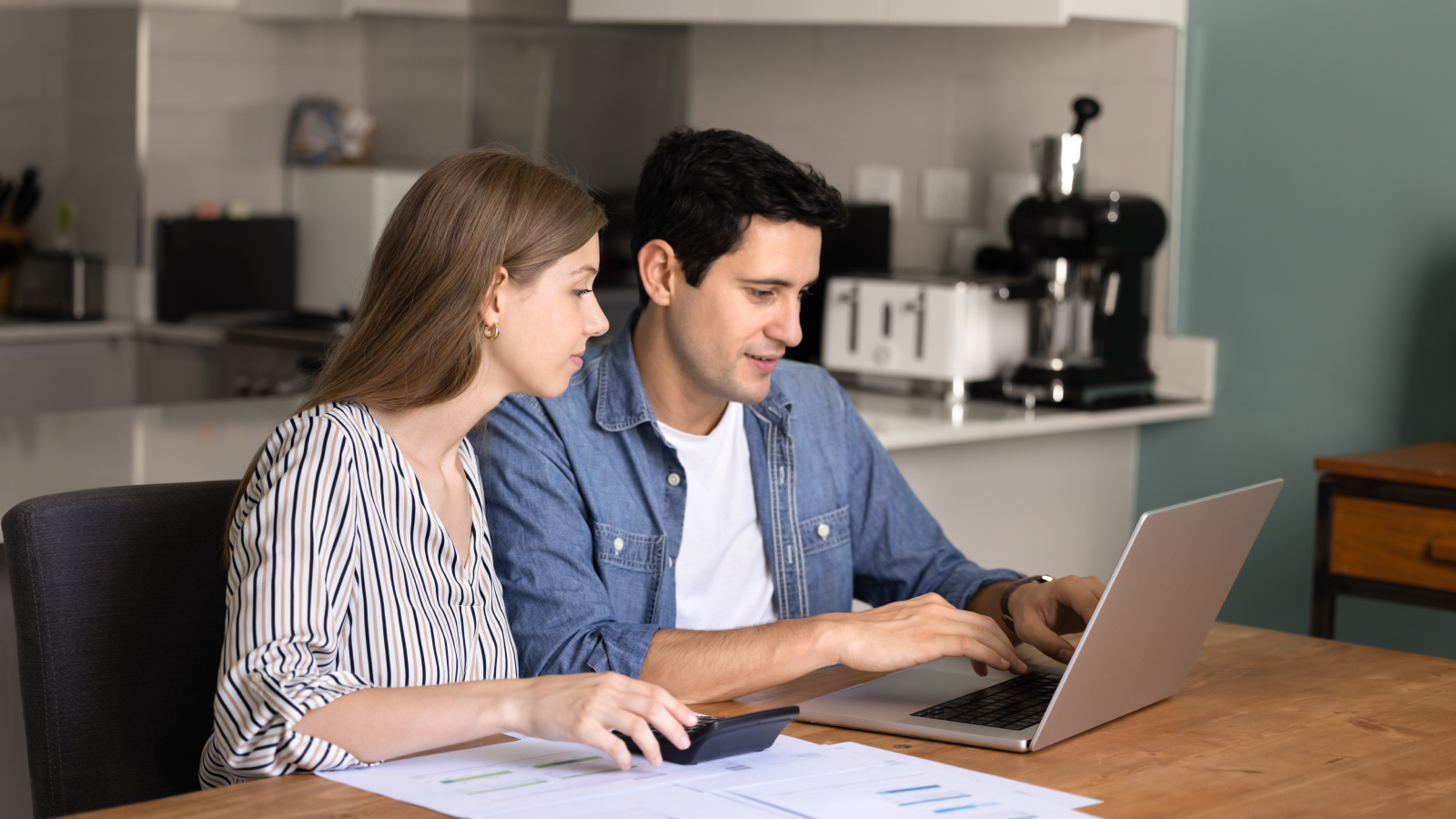 Sort out your finances How to start a dropshipping business A couple (man and woman) sitting in front of a laptop and figuring out how to start a dropshipping business.