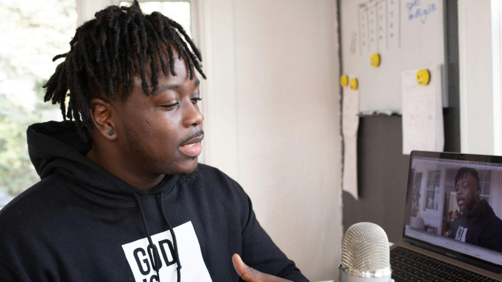 Start a podcast How to make money as an influencer A man in a black hoodie recording a podcast.