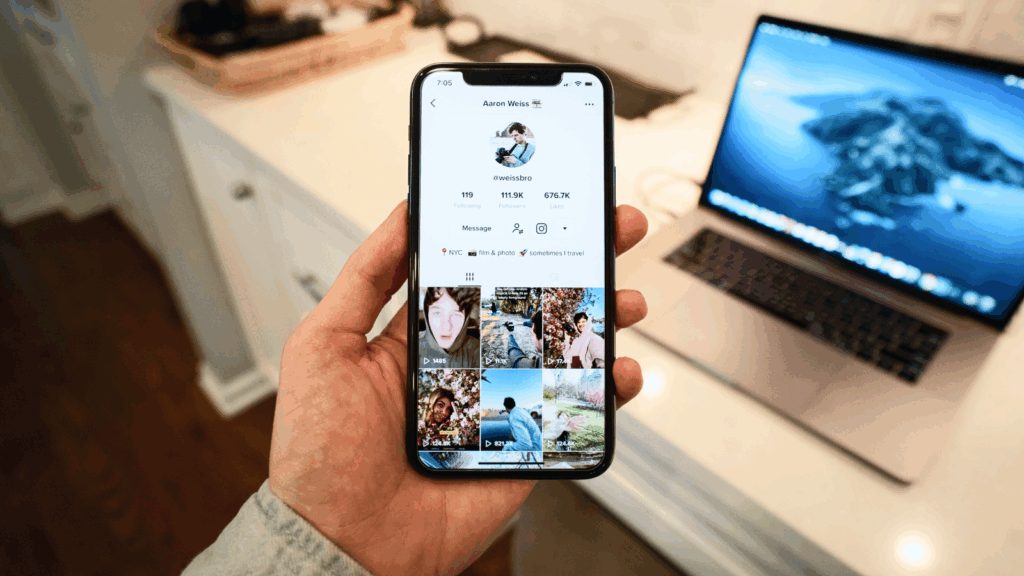 Tap into TikTok ads A man holding a mobile phone in his hand with the TikTok app open.