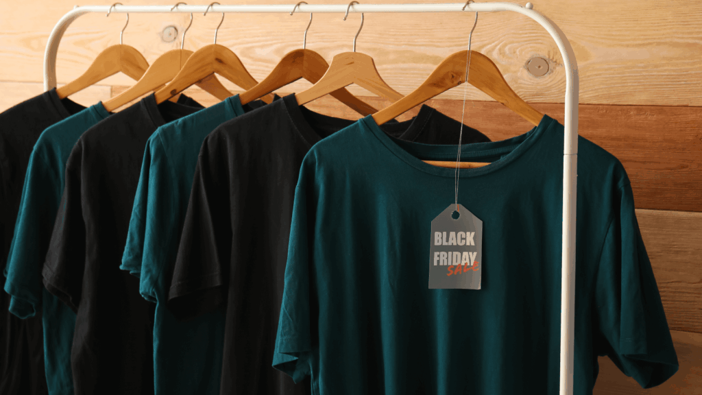 What are the types of t shirts based on their fabric weight Black Friday t-shirts displayed on hangers, showcasing various designs and colors for holiday shopping.