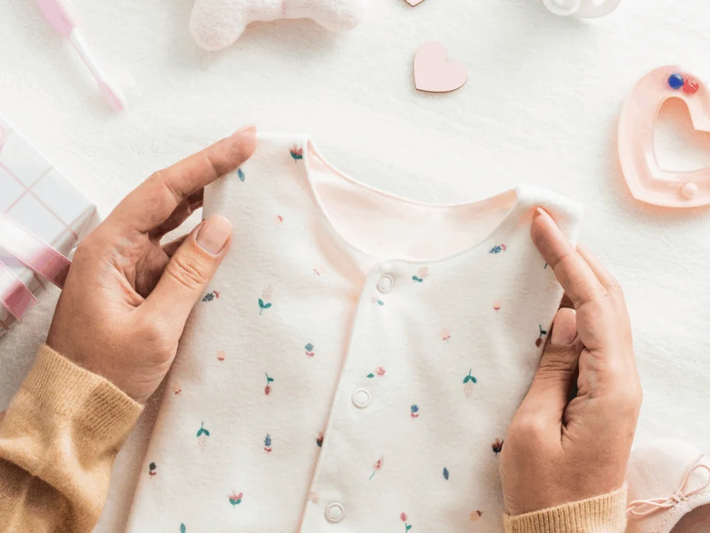 A woman holding a piece of child clothing.