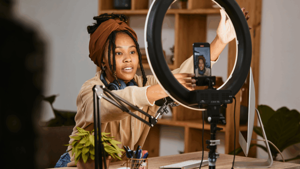 Best practices and tools for TikTok Shop Ad creatives A woman adjusting the lighting before recording herself with a mobile phone.