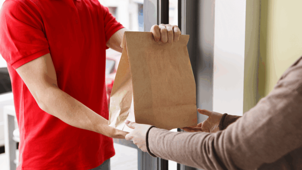 Do food delivery – Bring meals to doorsteps in your free time A courier delivering an order to the person.