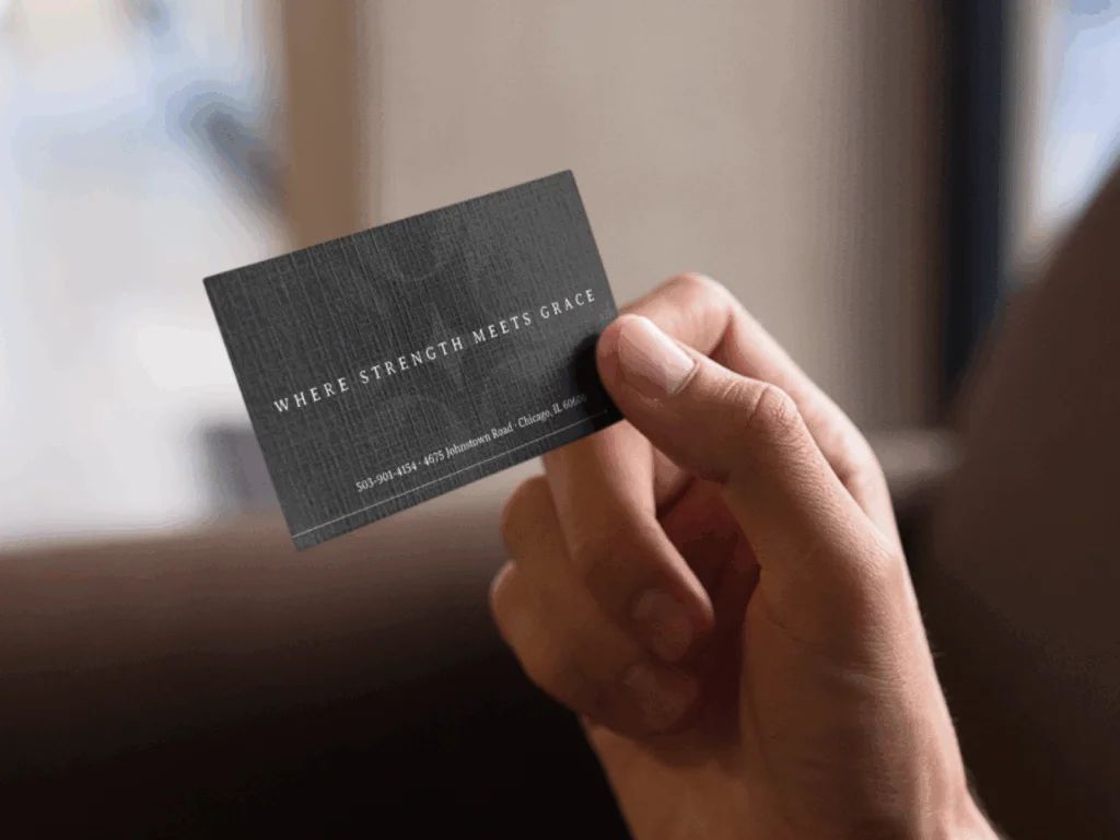 A person holding a custom business card in black.