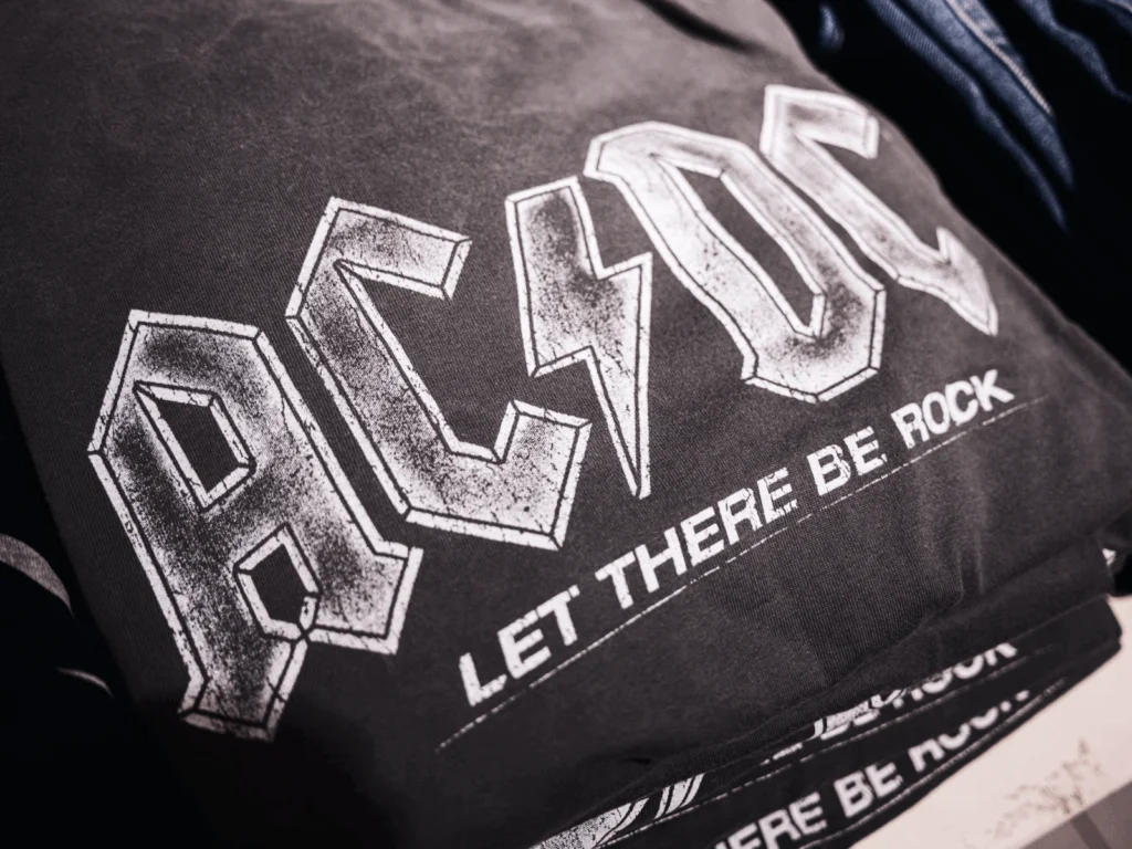 A black “AC/DC” t-shirt as an example of festival swag.