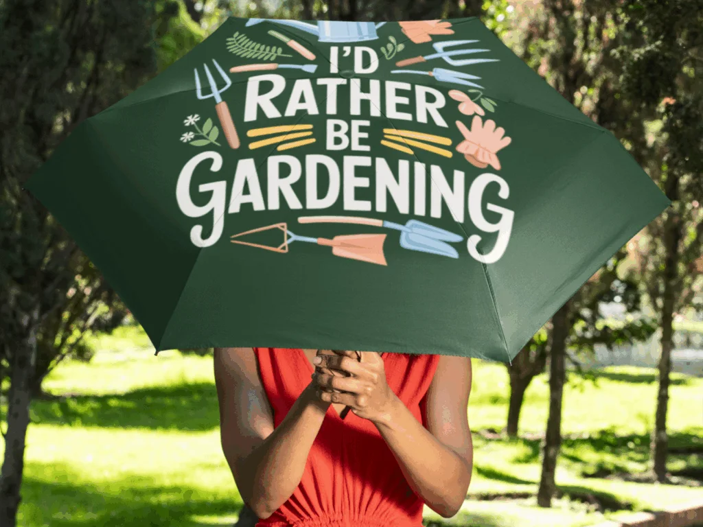 A woman holding an open umbrella with a “I’d rather be gardening” print.