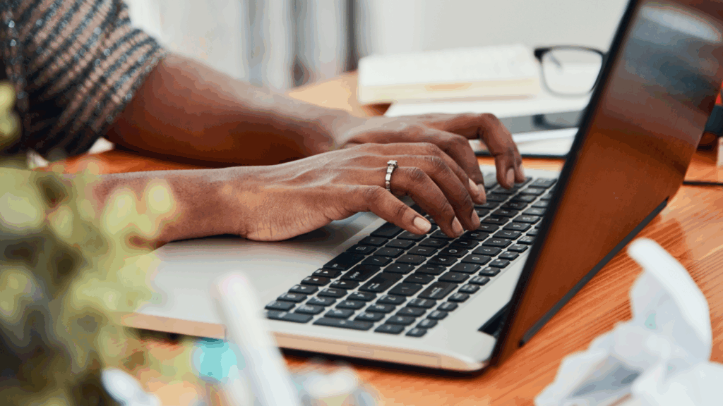 Get paid to write with freelance writing A person typing on a laptop keyboard.