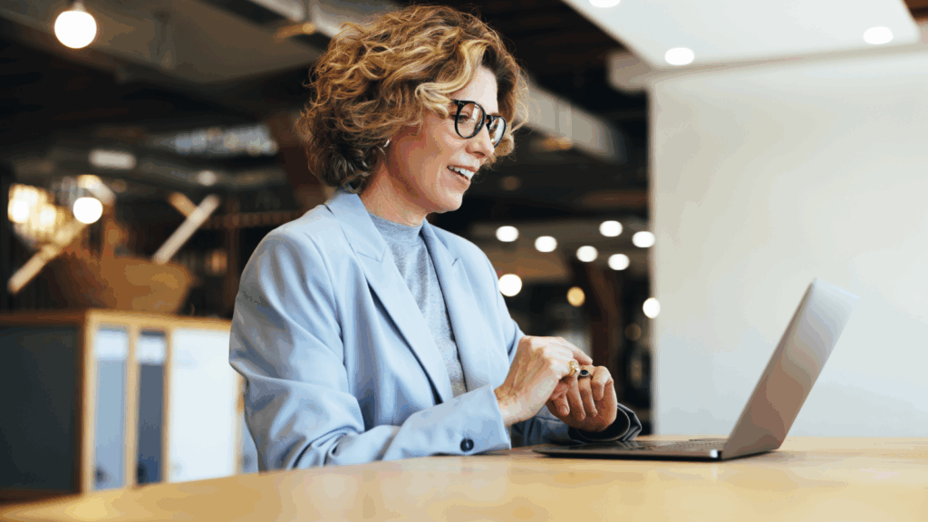How to test a business idea without huge investments A woman wearing glasses is focused on using a laptop at a desk.