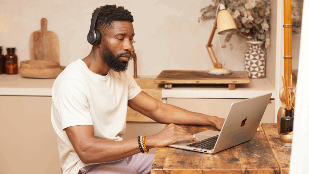 Pick a sales channel A man is sitting at a kitchen table and using a laptop to find information on product customization.