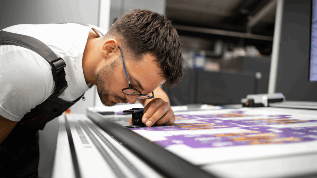 Print vs original Whats the difference A man in glasses is inspecting a print.