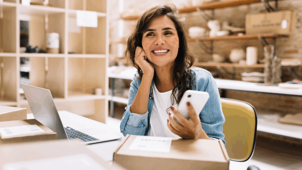 Sell without inventory with dropshipping A smiling woman is using a mobile phone to do dropshipping as a side business idea.