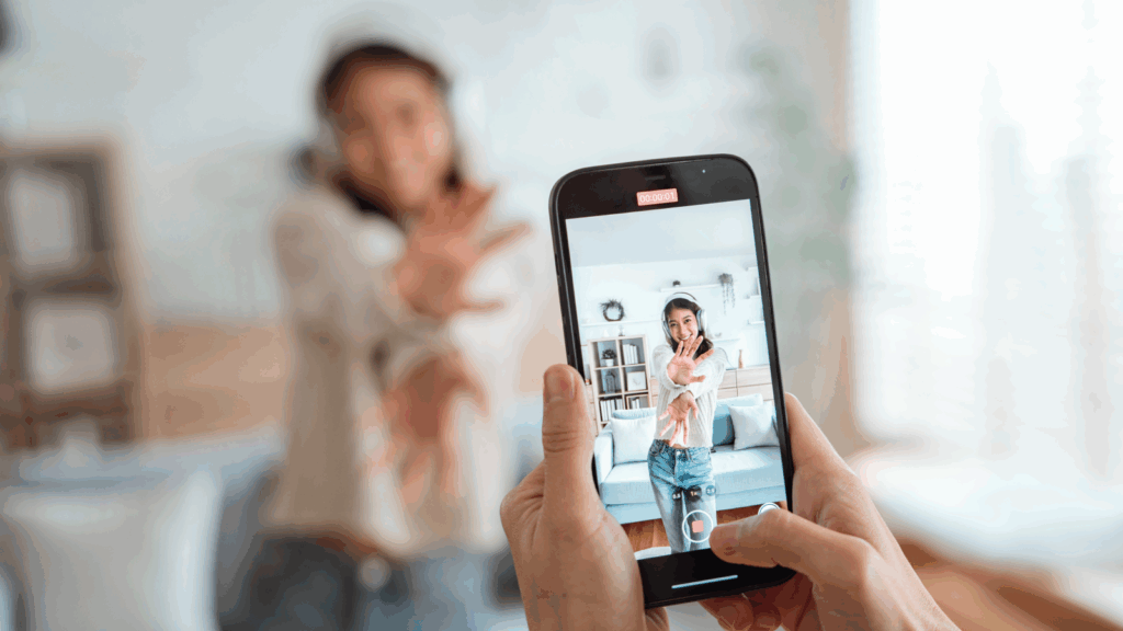 TikTok dos and donts A young woman in headphones is being recorded using a mobile phone.