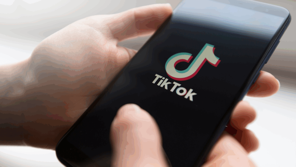TikTok hashtags How do they work A person is holding a mobile phone with the TikTok app loading screen.