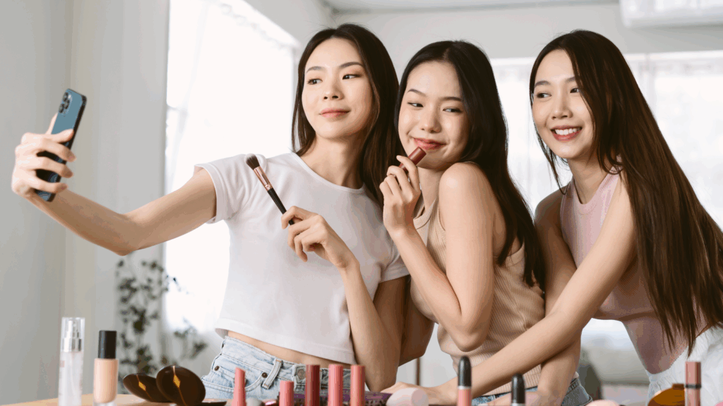 Top 10 TikTok hashtags Three women are holding make-up products and recording themselves using a mobile phone.