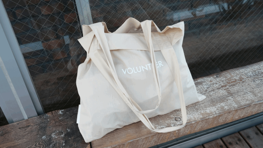 Tote bags Etsy shop ideas A cream tote bag featuring the word "volunteer" prominently displayed on its surface.