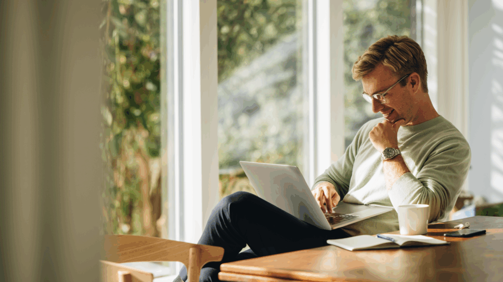 Try affiliate marketing A man seated at a table, focused on his laptop.