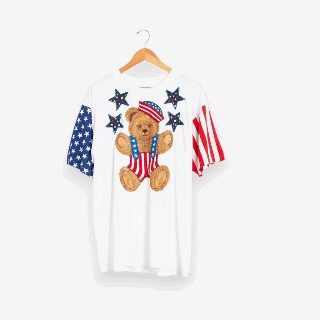 White vintage 4th of July-themed t-shirt with stars and a toy bear.