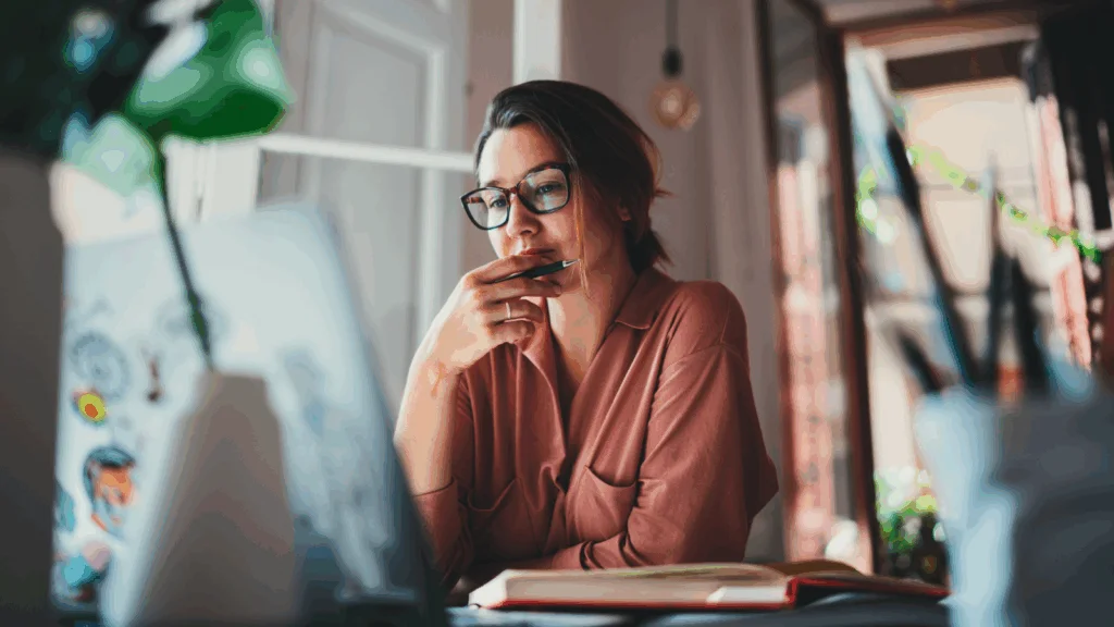 A woman is sitting in front of a laptop and reading about Canada tariffs.