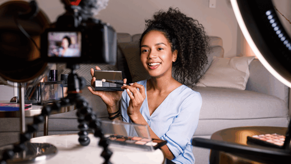 A content creator is presenting makeup products and recording herself using a camera.
