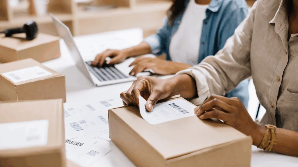 A person is sticking a delivery sticker onto a box.
