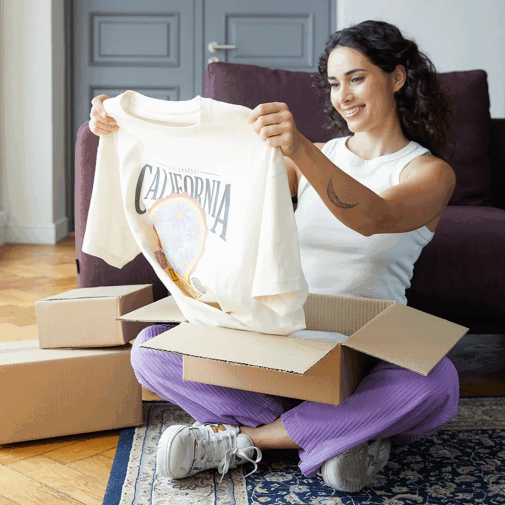 A woman unpacking a t-shirt.