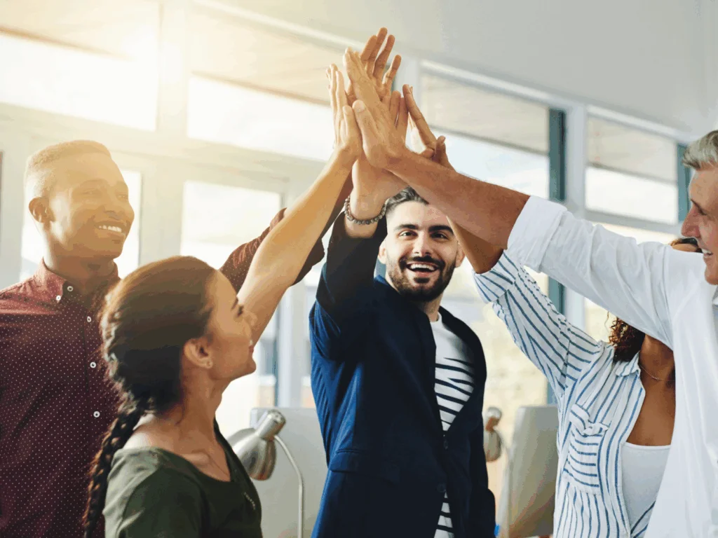 A group of smiling people high-fiving each other.