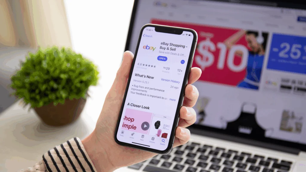 A person is holding a mobile phone with the eBay app open.