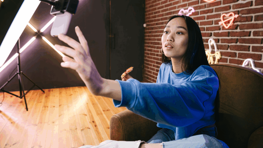 A woman smiling while taking a selfie with her phone, capturing a moment of joy.