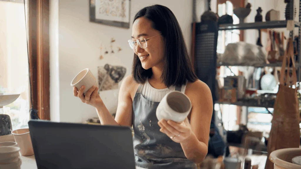 A woman is holding two mugs.