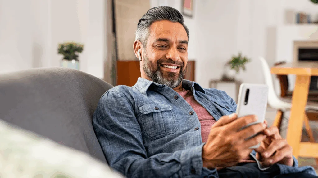 A man is using his phone to find the best AI tools for eCommerce and social media management.