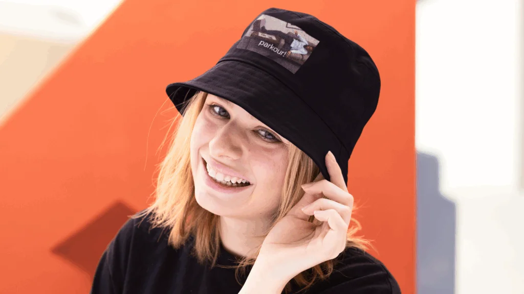 A woman with a black hat smiles warmly at the camera.