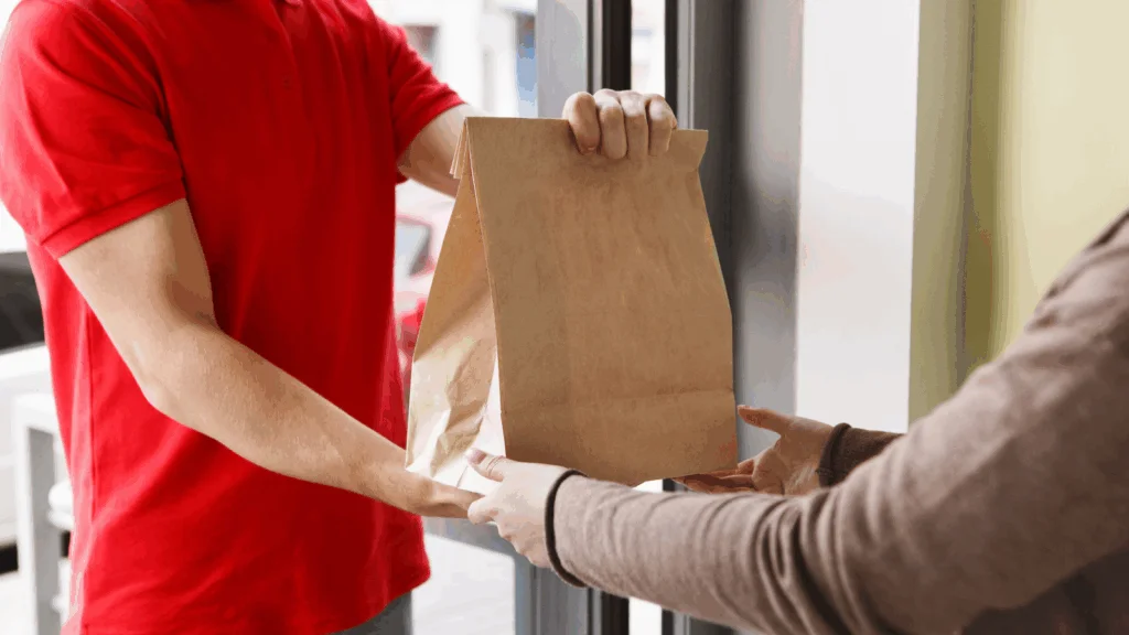 Gig economy and side hustle apps A man hands a brown paper bag to another person in a casual exchange.