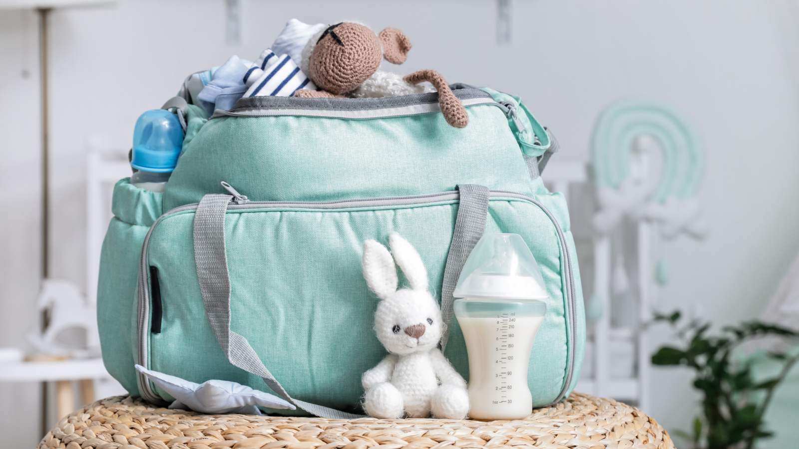 A green diaper bag filled with colorful stuffed animals and toys, ready for a day out with a baby.