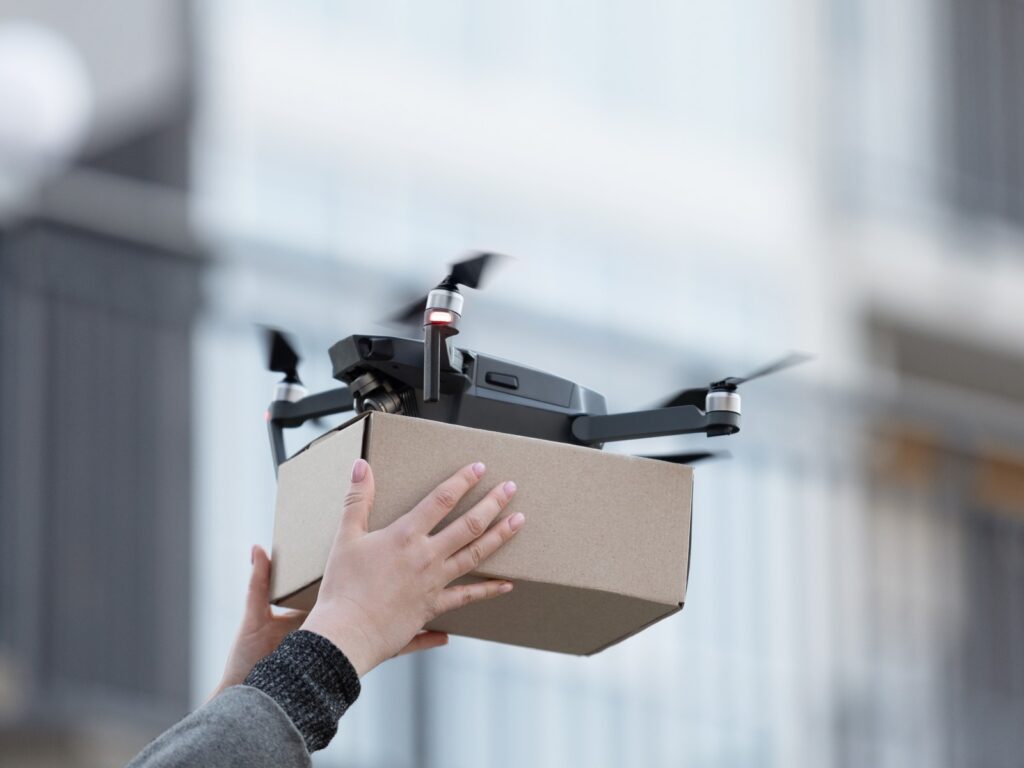A person holding a box containing a drone, showcasing the product ready for use or demonstration