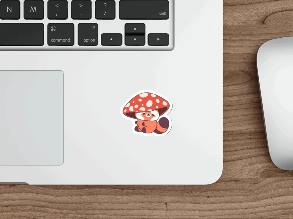 A colorful mushroom sticker affixed to the surface of a laptop