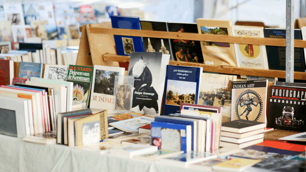 A wooden table displaying a variety of books in different sizes and colors