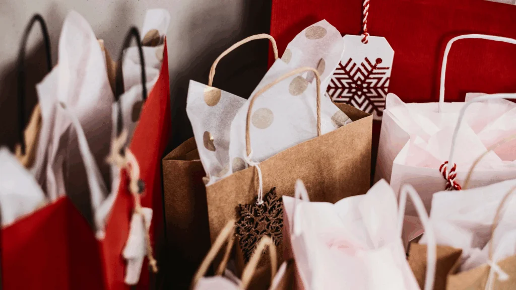 A room filled with numerous bags of Christmas gifts, creating a festive and cheerful atmosphere.