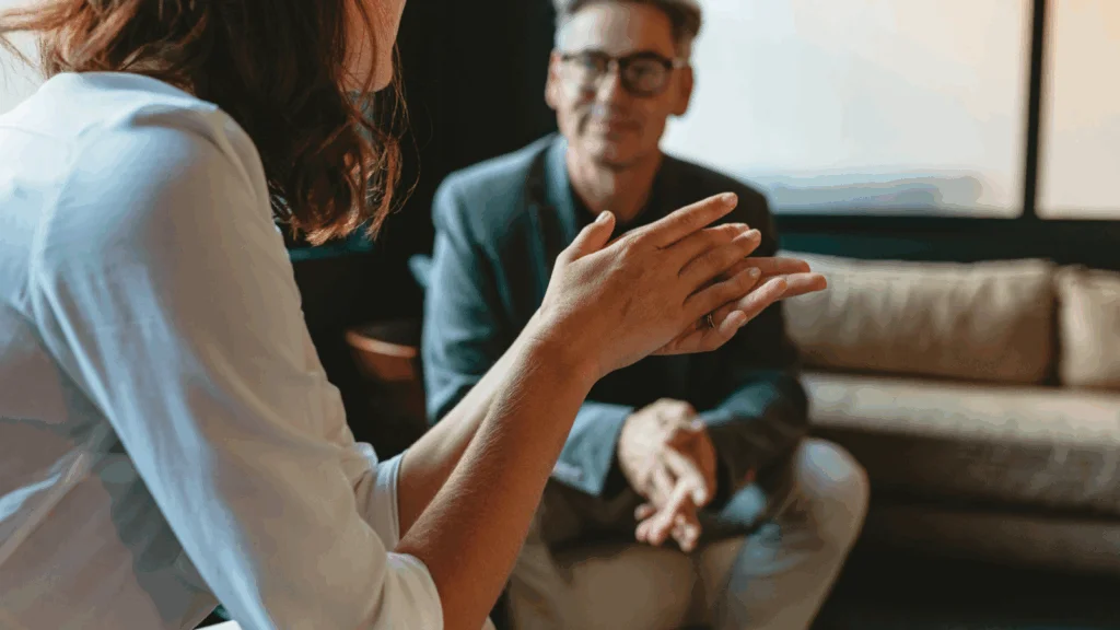 A man and woman engaged in conversation while sitting together on a comfortable couch.