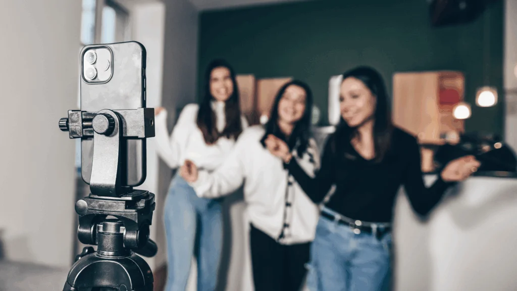 Three women stand together, smiling in front of a camera, ready for a photo.